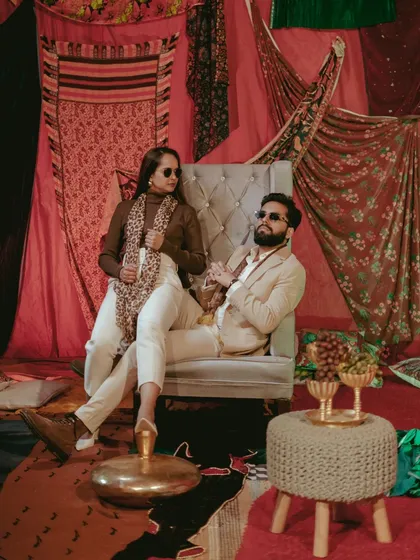 A stylish, high-fashion portrait of the couple on a lavishly decorated indoor set. This shot has a confident and modern editorial feel.