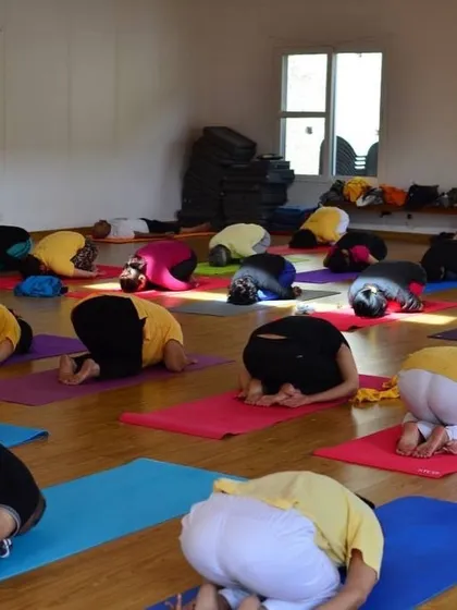 A group of students in Balasana, the child's pose, during a TTC. This posture provides rest and an opportunity for introspection during a long asana class.