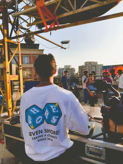A view from behind, showing off my Seven Shores shirt while I play for the crowd in Ahmedabad. Taking a chance since 2018.