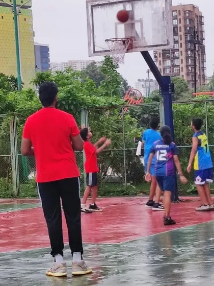 A coach watches over a practice game in the rain. Our commitment to training is unwavering, no matter the conditions.