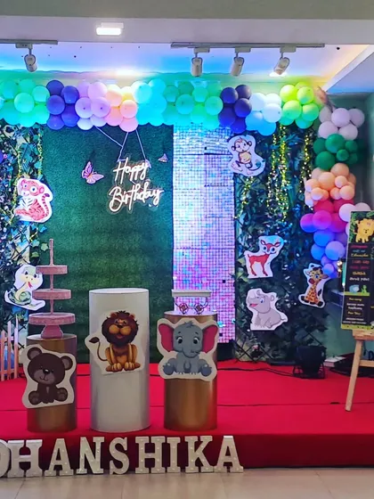 A clear, straight-on shot of the woodland animal stage setup, showcasing the balanced composition of balloons, backdrops, and props.
