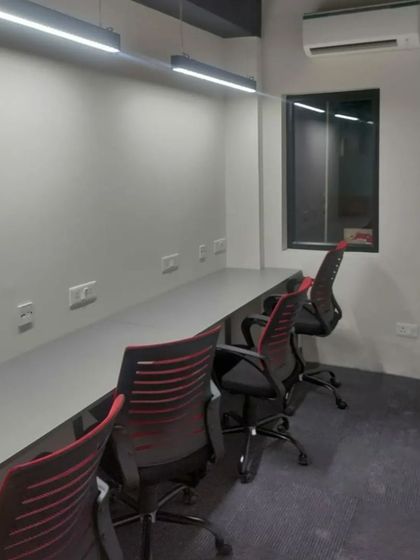 A nearly completed co-working space we furnished. This image shows the long, minimalist desks and chairs we installed, creating a clean and functional work environment.