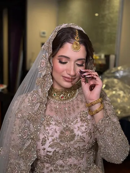 This close up captures the delicate details of the bride's makeup, including the soft pink eyeshadow and the traditional nose ring. The overall look is one of gentle, ethereal beauty.