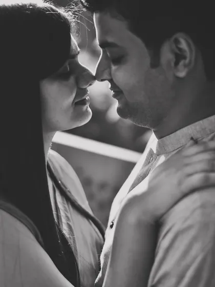 A classic and romantic black and white close-up. This timeless portrait captures the gentle intimacy between the couple, nose to nose.