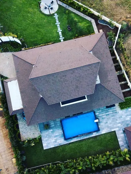 This top-down aerial view clearly shows the relationship between the house, the pool, and the garden. Our design ensures that the main living areas of the home have beautiful views of the green landscape.