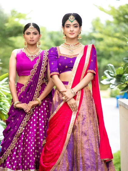Our collection includes beautiful options for bridesmaids, like these coordinated South Indian half sarees. The rich purple and pink silks with traditional borders offer a classic and cohesive look for the entire bridal party.