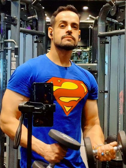 Even Superman has to work for his strength. Here I am doing dumbbell curls, a fundamental exercise for building bicep size and definition.