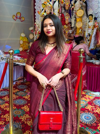 Accessories can make or break a look. For this festive style, I paired my maroon Benarasi with a bright red bag to add a pop of contrasting color, making the whole outfit stand out.