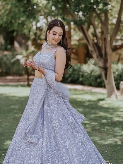 The bride twirls in her beautiful lehenga, her wavy hair moving with her.