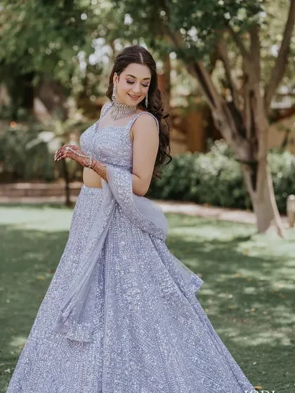 The bride twirls in her beautiful lehenga, her wavy hair moving with her.