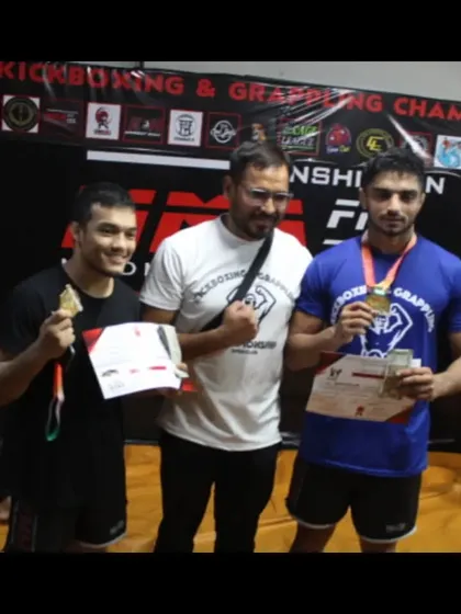 Two of our grappling champions with their coach, proudly displaying their gold medals.