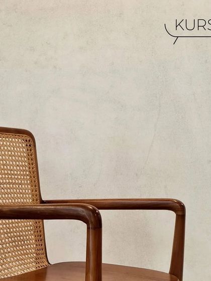 A close-up of the 'Tara' armchair's armrest and rattan back. This classic teak chair is comfortable enough for a study desk or a dining table.