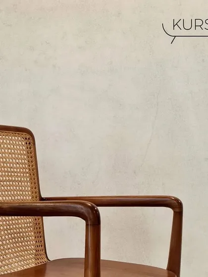 A close-up of the 'Tara' armchair's armrest and rattan back. This classic teak chair is comfortable enough for a study desk or a dining table.