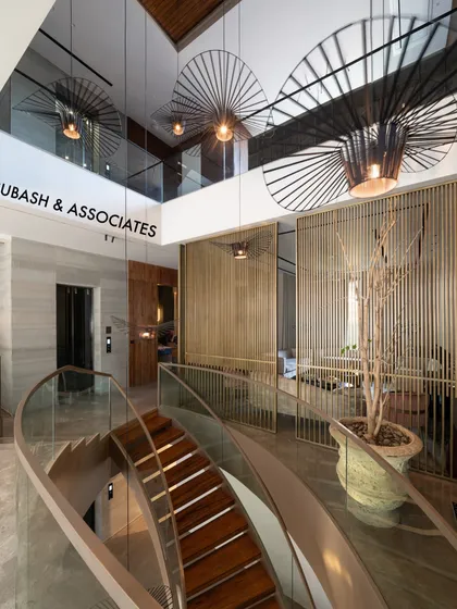 A staircase should be more than functional; it should be a sculptural centerpiece. This curved staircase combines wood, glass, and metal, complemented by dramatic pendant lighting to create a striking focal point in the home.