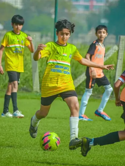 A player leads the charge, dribbling the ball forward while his teammates follow in support during a fast-paced attack.