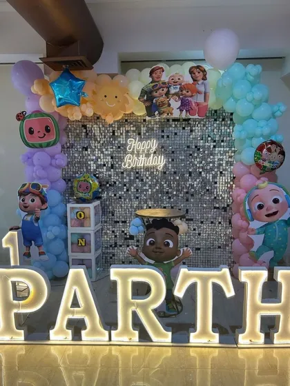 For Parth's first birthday, we combined a Cocomelon theme with a silver sequin wall. The large marquee letters and character cutouts made it a perfect photo spot.