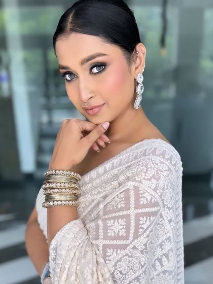 Another angle of this stunning look, showcasing the clean lines and flawless complexion. The sleek bun and statement earrings complete this elegant party style.