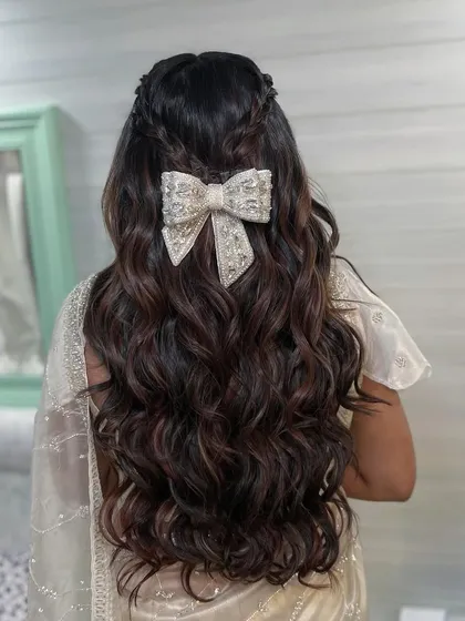 Another angle of the stunning bow hairstyle. The intricate beading on the bow catches the light beautifully, making it a perfect accessory for an engagement or reception.