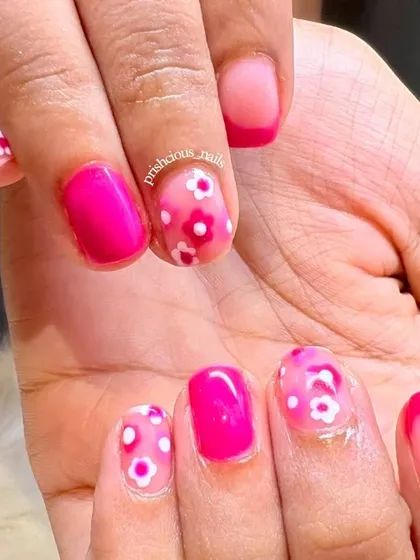 A closer look at the pink floral nails. The mix of solid pink, French tips, and floral art makes this set playful and fun.