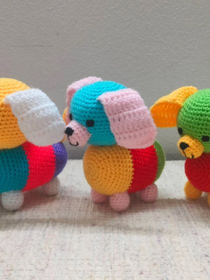 Another view of the three colorful dogs, showing their cute faces and floppy ears.