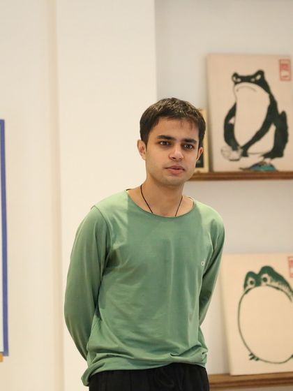 A young student listens intently at our 'Chai & Poetry' event. These sessions are a safe space to learn and be inspired by other performers.