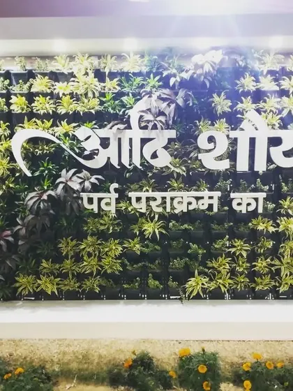 A night-time view of the illuminated signage on the Nehru Stadium living wall. The lighting makes the feature stand out as a stunning landmark after dark.