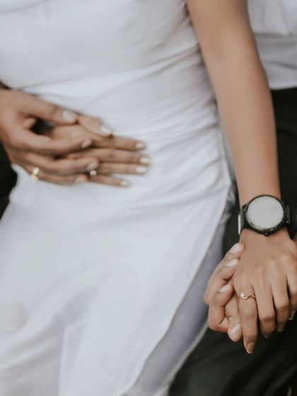 A detail shot focusing on the couple's hands and embrace during their water photoshoot. This highlights intimacy and connection without showing faces.