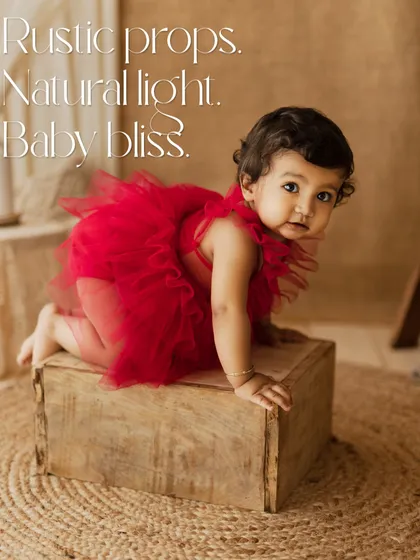 Rustic props, natural light, baby bliss. This little one in a vibrant red tutu is exploring a wooden box, a beautiful contrast of color and texture.