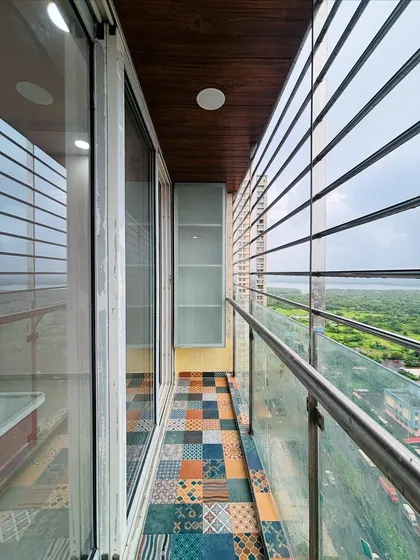 Another view of the balcony, showing a slim storage cabinet and a wooden ceiling panel, which adds warmth and a finished look to the space.