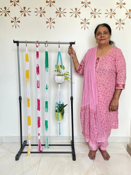 I love playing with colors. Here are some of my macrame plant hangers in bright yellow, pink, and green, alongside a couple of classic white ones holding pots. We can customize the colors and patterns to give your green friends a beautiful new home.