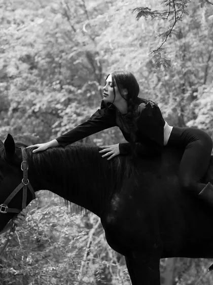A serene and beautiful shot of a model connecting with a horse, taken during a professional photoshoot in our natural surroundings.