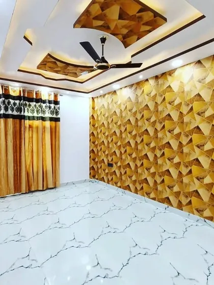 Yahan ceiling ka design deewar ke wallpaper se match kiya gaya hai. Beech mein geometric pattern wala panel lagaya hai jo room ko ek unique character deta hai.