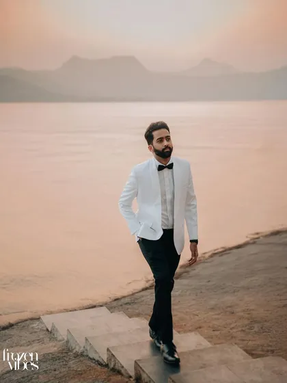 Himanshu walking along the lakeside as the last light of day paints the water in soft hues. This is a great example of a cinematic groom portrait.