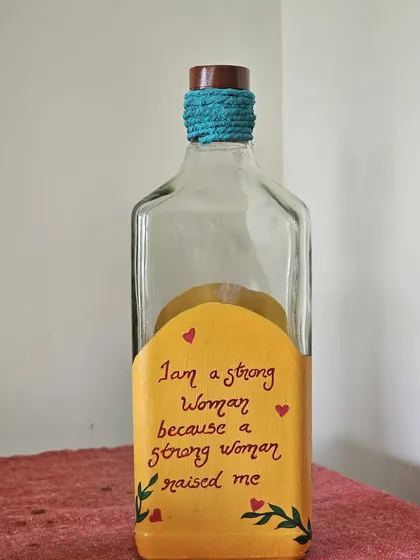 A bottle painted during our Mother's Day workshop with the quote, "I am a strong woman because a strong woman raised me."