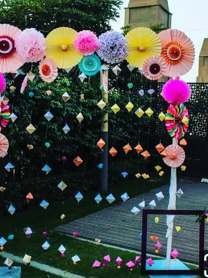 To showcase our creative range, we designed this modern and playful photo booth arch for a Mehendi party. The structure is adorned with a collage of colorful paper fans, bright pom-poms, and a curtain of hanging geometric shapes. This style is perfect for clients looking for a unique, non-traditional decor theme that is full of color and energy.
