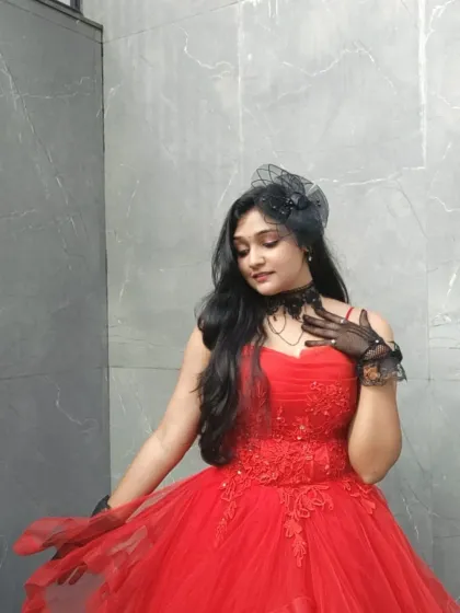 A client looking beautiful in our red ball gown after winning her "Ms. Elegant" title. This dress features delicate lace embroidery and a full tulle skirt.