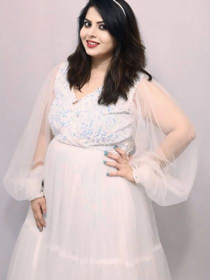 This dreamy white gown features a sequined bodice and sheer, puffy sleeves. It's a versatile piece that's perfect for pre-wedding shoots, maternity photos, or birthday parties.
