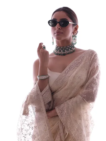 A chic and modern jewelry campaign look. I paired a classic white embroidered saree and a heavy emerald choker with a pair of cool, black sunglasses, creating a fusion of traditional elegance and contemporary attitude.