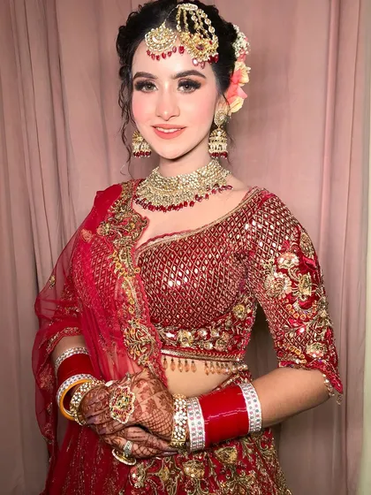 A happy bride, her smile lighting up the frame. The floral bun adds a fresh, modern touch.