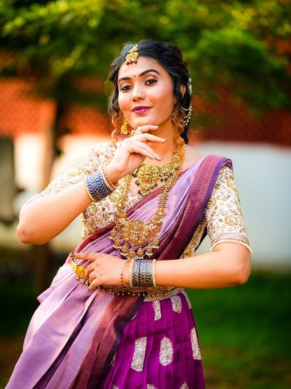 This pose highlights the rich temple jewellery that pairs so well with a traditional langa voni. The heavily embroidered blouse and the silk skirt create a look that is both grand and graceful.