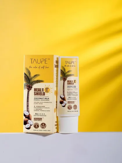 A sunny and bright product shot for Taupe's coconut milk sunscreen. The yellow background and shadow of a palm leaf instantly evoke a tropical, beachy feeling, perfectly matching the product.