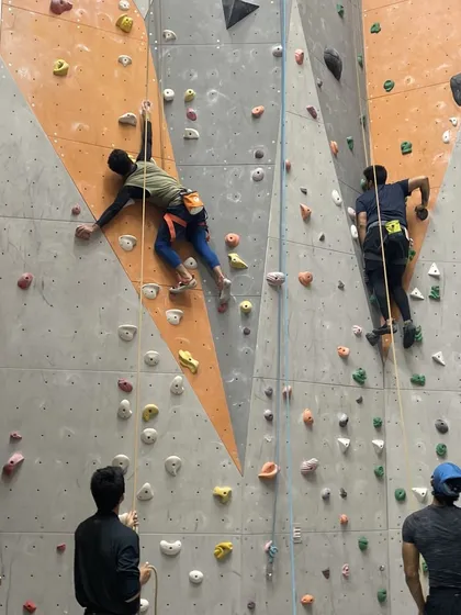 Two climbers ascend parallel routes, adding a little friendly competition to their session.
