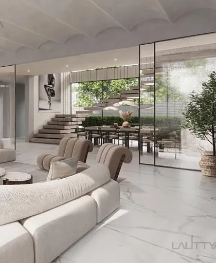 This living area concept was designed with comforting curves and natural textures. The open layout connects the living and dining areas, separated by large glass partitions that maintain a sense of spaciousness while defining the zones.