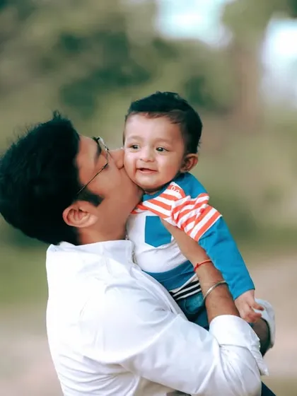 A father's gentle kiss for his son during their family portrait session. I focus on capturing these small, affectionate gestures that tell the story of your family's love.