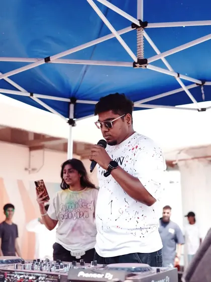 On the mic, interacting with the crowd during the Holi celebration. Constant engagement is key to keeping the energy high.