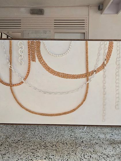 This large-scale 3D chain artwork is being delivered to a client. This piece was a significant commission that involved creating various chain styles with air-drying clay, painted in gold and white.
