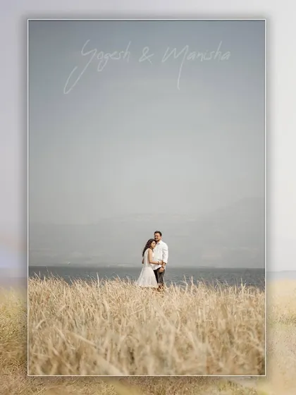 A beautiful landscape portrait with the couple standing in a field of tall grass by the water, perfect for a save-the-date.