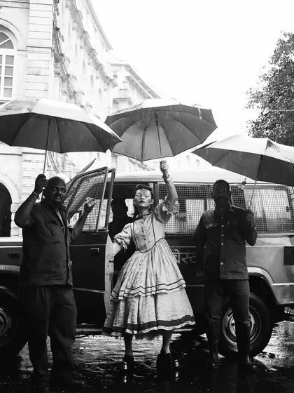 An earlier shot from the same "RIOT" concept, captured in black and white. The rain-soaked street and umbrellas add a layer of spontaneous drama to this rebellious fashion moment.
