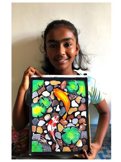 The talented artist with her koi fish painting. Her focus and skill are truly impressive, and the result is a beautiful piece of art.