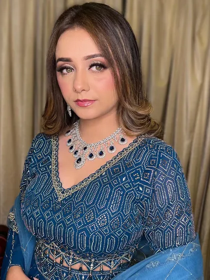 A beautiful portrait of the bride, showcasing her flawless makeup and elegant blue attire.
